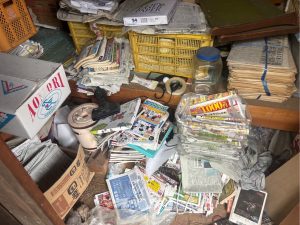 膨大な紙類や雑誌類が部屋を埋め尽くす状態